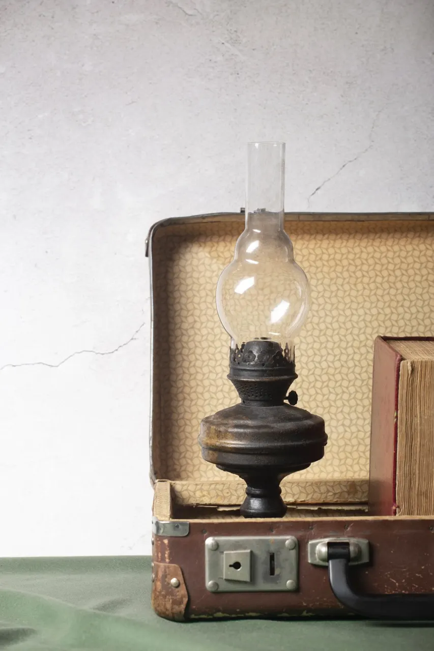 Lampe à pétrole posée dans une valise ancienne